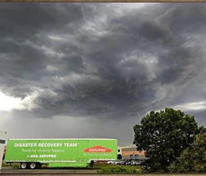 black clouds in sky with a SERVPRO trailer